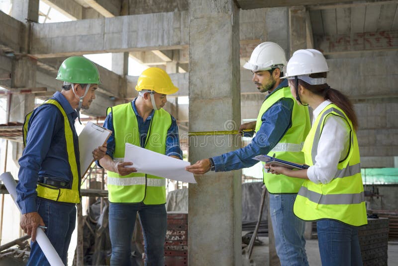 مهندسان نظارت بر ساختمان در حال اندازه‌گیری ستون‌های بتنی برای اطمینان از انطباق با استانداردهای ساخت